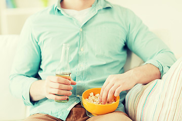 Image showing close up of man with popcorn and beer at home