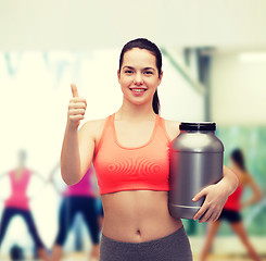 Image showing teenage girl with jar of protein showing thumbs up