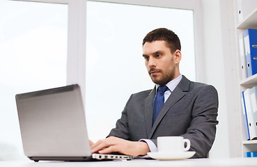 Image showing businessman with laptop typing in office