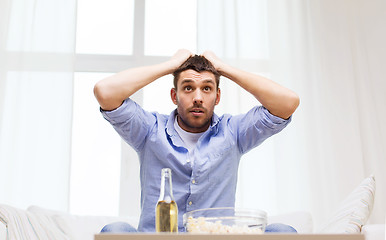 Image showing smiling man watching sports at home