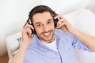 Image showing smiling young man in headphones at home