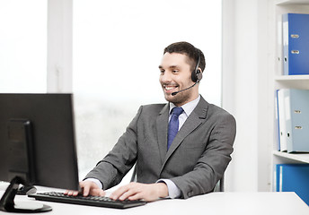 Image showing helpline operator with headphones and computer