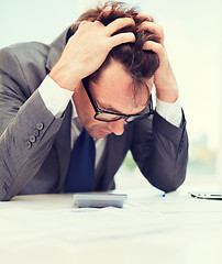 Image showing businessman with papres, laptop and calculator