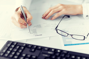 Image showing woman hand filling in invoice paper