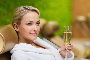 Image showing beautiful young woman drinking champagne at spa