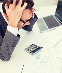 Image showing businessman with papres, laptop and calculator