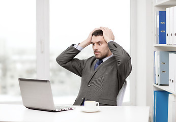 Image showing busy businessman with laptop and coffee