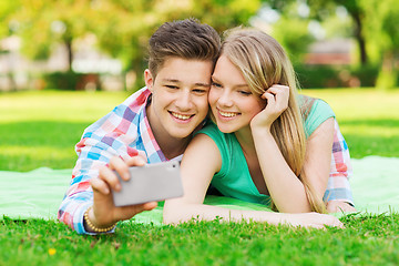 Image showing smiling couple making selfie in park