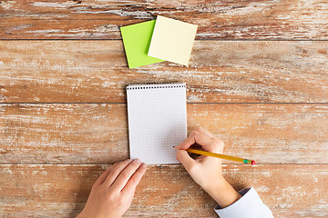 Image showing close up of hands with notebook and stickers