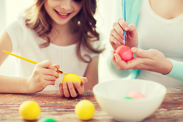 Image showing close up of little girl and mother coloring eggs