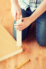 Image showing close up of male hands assemblying legs to table