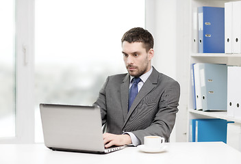 Image showing busy businessman with laptop and coffee