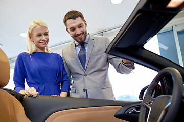 Image showing happy couple buying car in auto show or salon