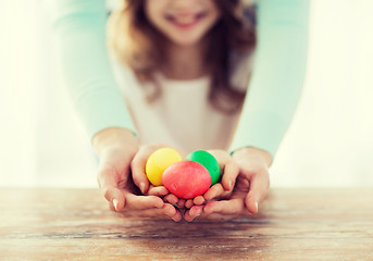 Image showing close up of girl and mother holding colored eggs