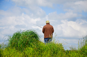 Image showing Fisherman in anticipation of the catch  with a fishing rod on th