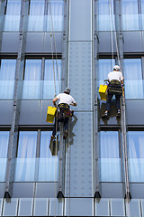 Image showing Two climbers wash windows