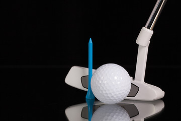 Image showing Golf putter and gold equipments on the black glass desk