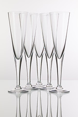 Image showing Five champagne glasses on a glass desk