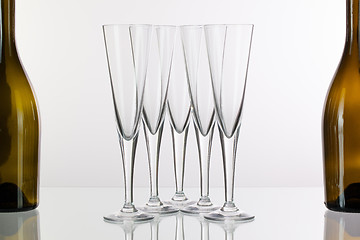 Image showing Five champagne glasses on a glass desk