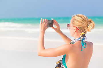 Image showing Woman taking photo on the beach.