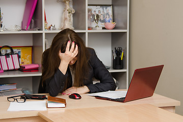 Image showing Girl in the office clutching her head