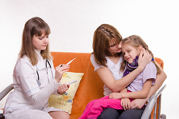 Image showing doctor looks temperature on a thermometer sick girl and her mother comforts