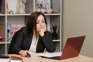 Image showing The girl in office of a tired looking into computer