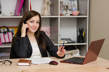 Image showing employee of office is a telephone conversation at computer