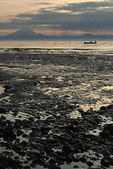 Image showing Cook inlet low tide beach with fisherman boat and volcanoe in ba