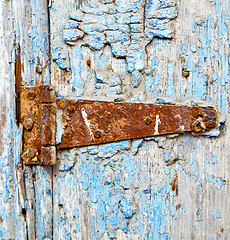 Image showing rusty metal     nail dirty stripped paint in the blue wood door 