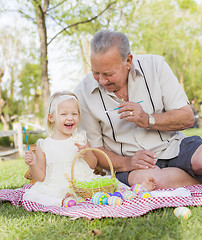 Image showing Grandfather and Granddaughter Coloring Easter Eggs on Blanket At