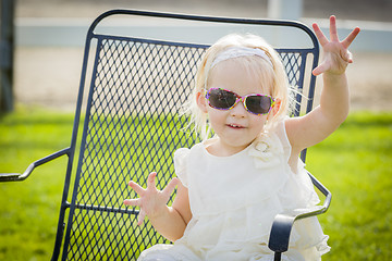 Image showing Cute Playful Baby Girl Wearing Sunglasses Outside at Park