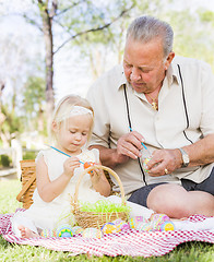 Image showing Grandfather and Granddaughter Coloring Easter Eggs on Blanket At