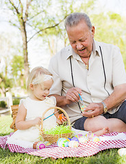 Image showing Grandfather and Granddaughter Coloring Easter Eggs on Blanket At