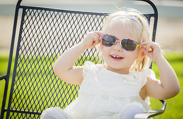 Image showing Cute Playful Baby Girl Wearing Sunglasses Outside at Park