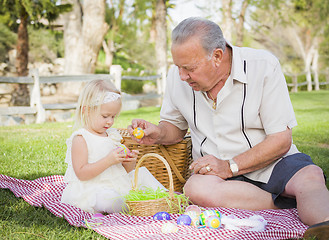 Image showing Grandfather and Granddaughter Enjoying Easter Eggs on Blanket At