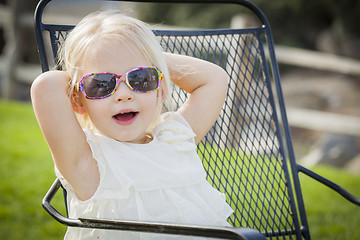 Image showing Cute Playful Baby Girl Wearing Sunglasses Outside at Park