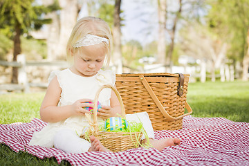 Image showing Cute Baby Girl Enjoying Her Easter Eggs on Picnic Blanket