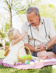 Image showing Grandfather and Granddaughter Coloring Easter Eggs on Blanket At