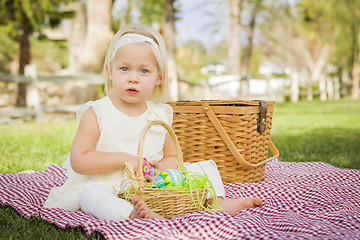 Image showing Cute Baby Girl Enjoying Her Easter Eggs on Picnic Blanket