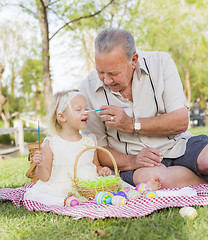 Image showing Grandfather and Granddaughter Coloring Easter Eggs on Blanket At