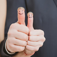 Image showing wedding rings on their fingers painted with the bride and groom, funny little people