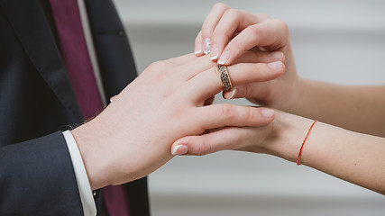 Image showing Bride putting a wedding ring