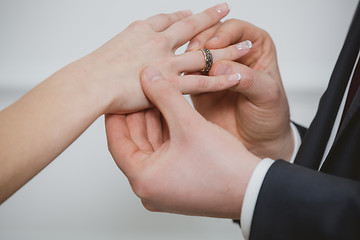 Image showing Groom put a ring on finger of his lovely wife.