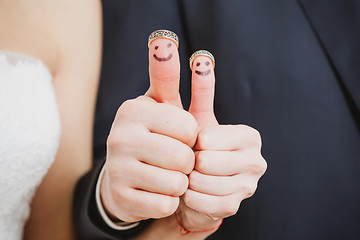 Image showing wedding rings on their fingers painted with the bride and groom, funny little people