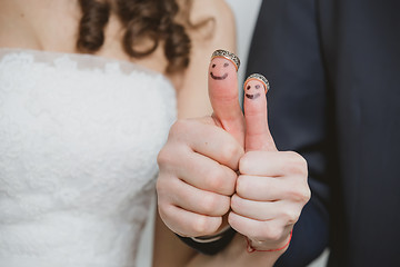 Image showing wedding rings on their fingers painted with the bride and groom, funny little people