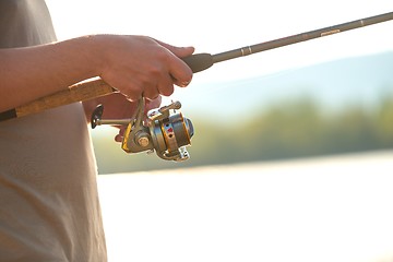 Image showing Modern clean fishing rod in hands