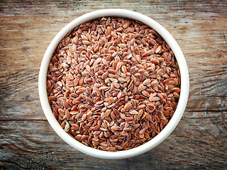 Image showing Bowl of flax seeds on old wooden table
