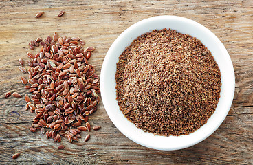 Image showing Bowl of crushed flax seeds on old wooden table