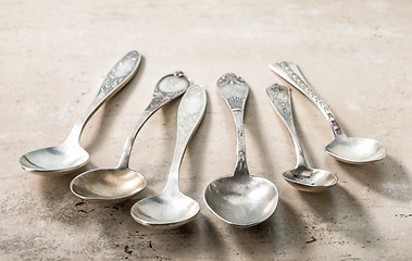 Image showing various empty silver spoons